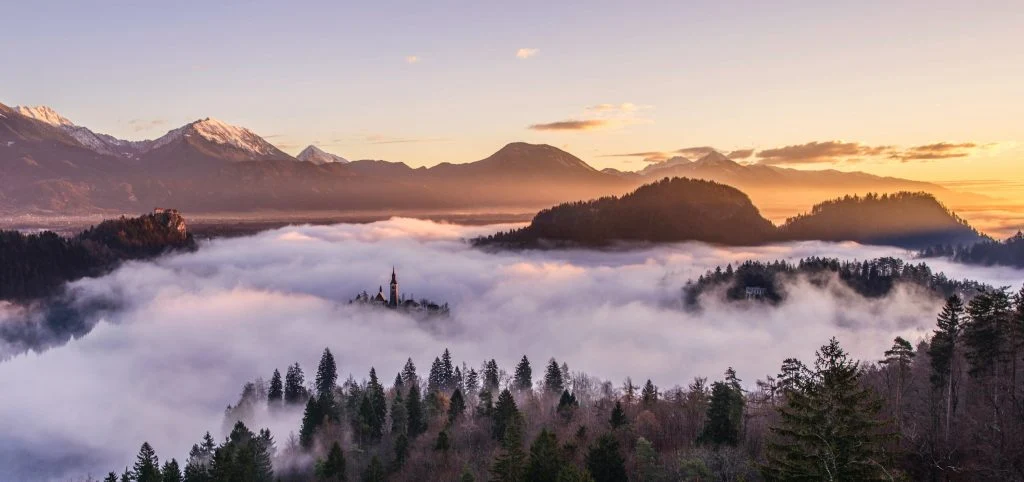 Mountain peaks above clouds at sunrise